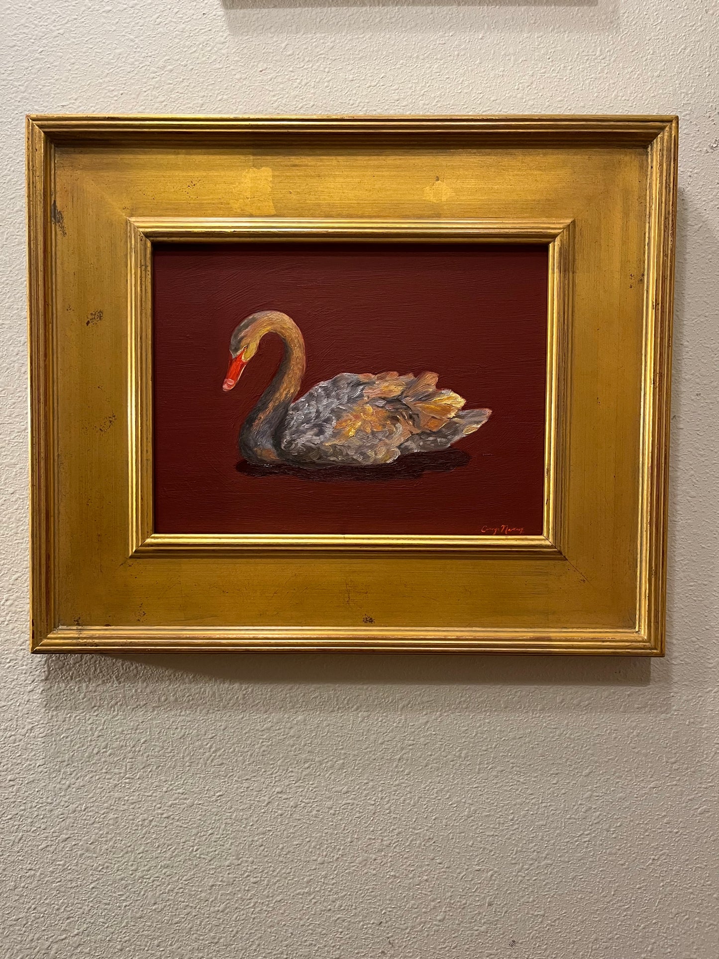 Framed artwork of a grey swan on a red background