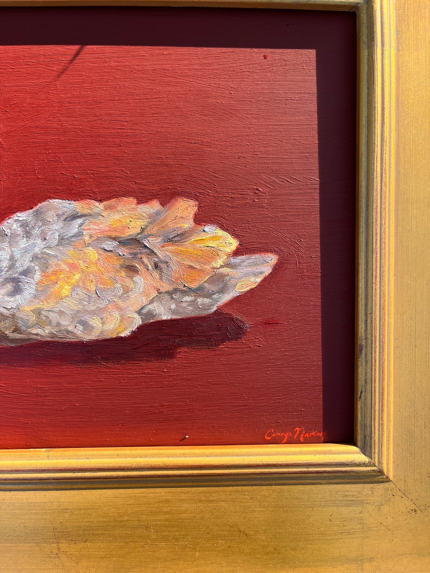 Cropped image of painting of a swan against a red background against a plein air frame