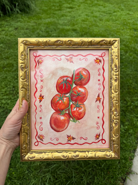 Framed artwork of tomatoes held over a grassy background